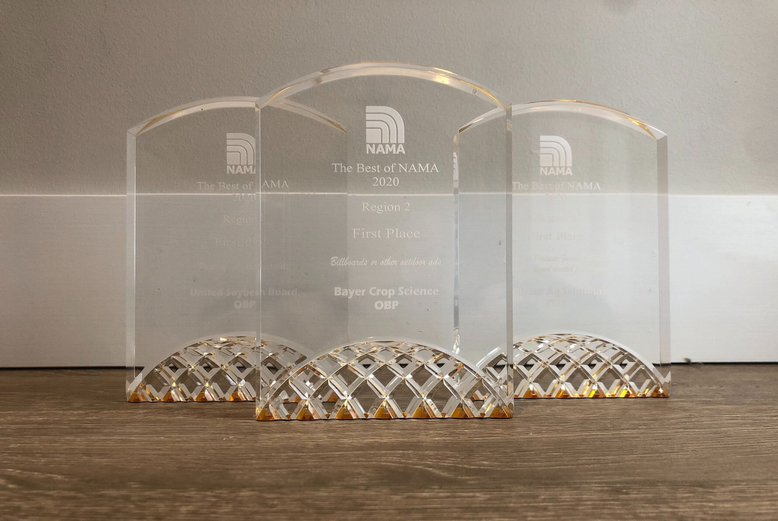 Three awards for The Best of NAMA 2020 sit on a wooden table. All three awards have been presented to OBP.